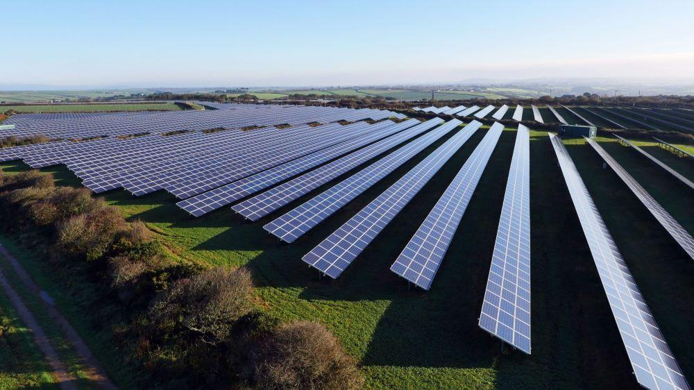 A solar farm viewed with from an elevated position on a sunny day